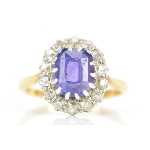 116 - An 18ct gold amethyst and diamond cluster ring, the central amethyst 7.9mm x 6.4mm, surrounded by a ... 