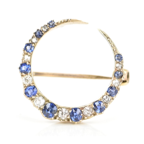 120 - A diamond and sapphire crescent brooch, set with eleven graduated sapphires, the largest 3mm x 2.6mm... 