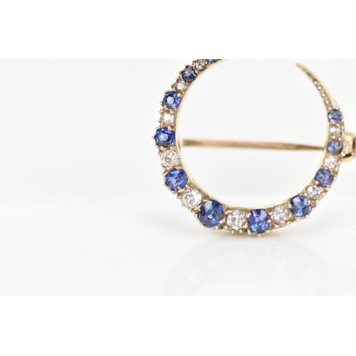 120 - A diamond and sapphire crescent brooch, set with eleven graduated sapphires, the largest 3mm x 2.6mm... 