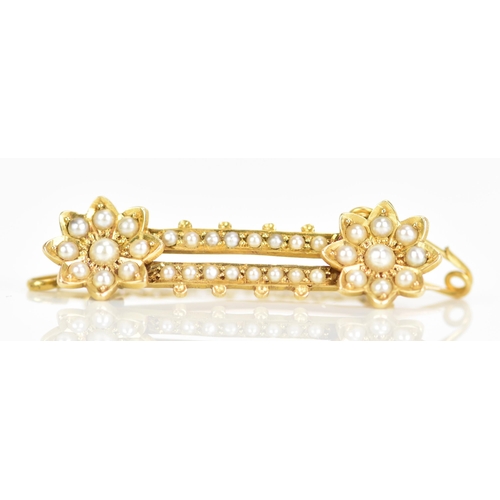 121 - A Victorian 18ct gold seed pearl brooch, having two flower heads united by two bars, each inset with... 