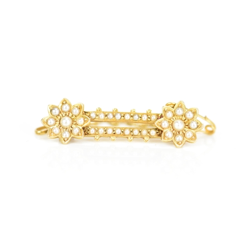 121 - A Victorian 18ct gold seed pearl brooch, having two flower heads united by two bars, each inset with... 