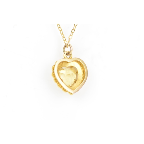 123 - A 15ct yellow gold citrine and seed pearl pendant with a yellow gold chain, the heart shaped pendant... 