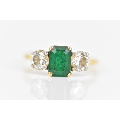 127 - A yellow gold emerald and diamond engagement ring, the emerald cut stone in a claw setting 7.7mm x 5... 