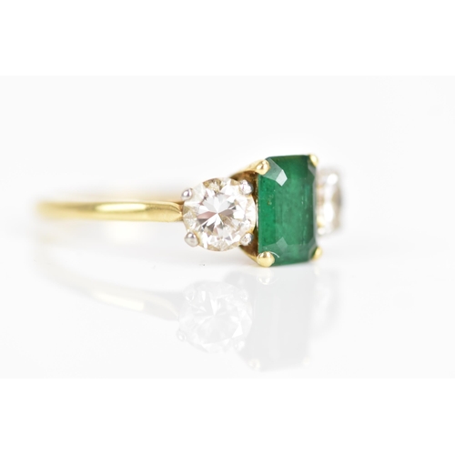 127 - A yellow gold emerald and diamond engagement ring, the emerald cut stone in a claw setting 7.7mm x 5... 