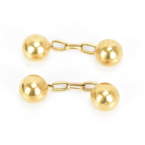 138 - A pair of 18ct yellow gold cufflinks, in the form of balls with chain links, stamped 18, combined we... 