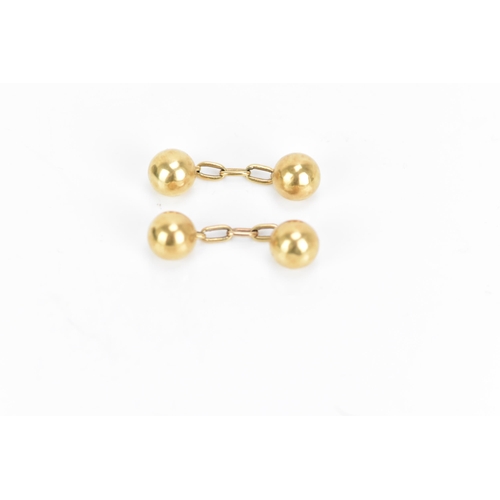 138 - A pair of 18ct yellow gold cufflinks, in the form of balls with chain links, stamped 18, combined we... 