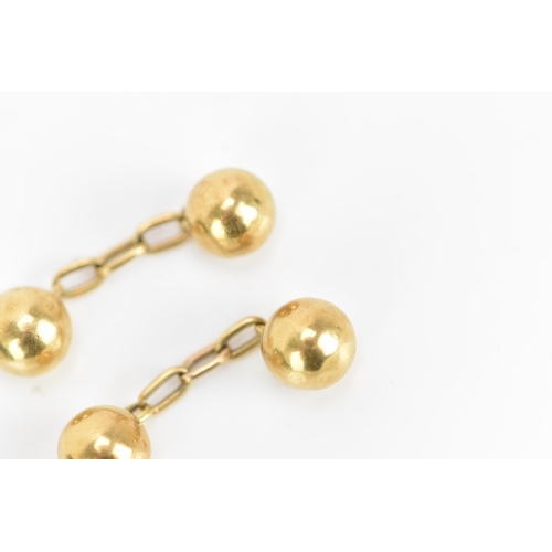 138 - A pair of 18ct yellow gold cufflinks, in the form of balls with chain links, stamped 18, combined we... 