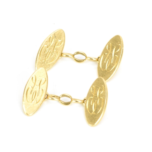 139 - A pair of 18ct yellow gold cufflinks, each of oval form with chain links and engraved with a monogra... 