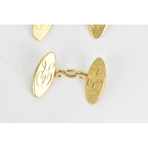 139 - A pair of 18ct yellow gold cufflinks, each of oval form with chain links and engraved with a monogra... 