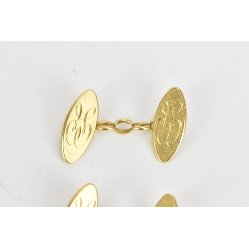 139 - A pair of 18ct yellow gold cufflinks, each of oval form with chain links and engraved with a monogra... 