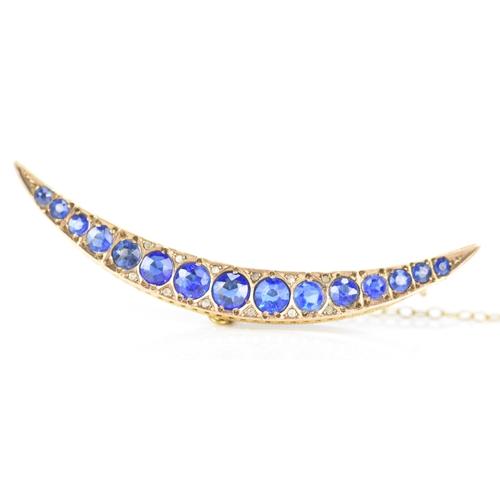 146 - An Edwardian 9ct gold crescent brooch, inset with fifteen blue coloured graduating stones and twelve... 