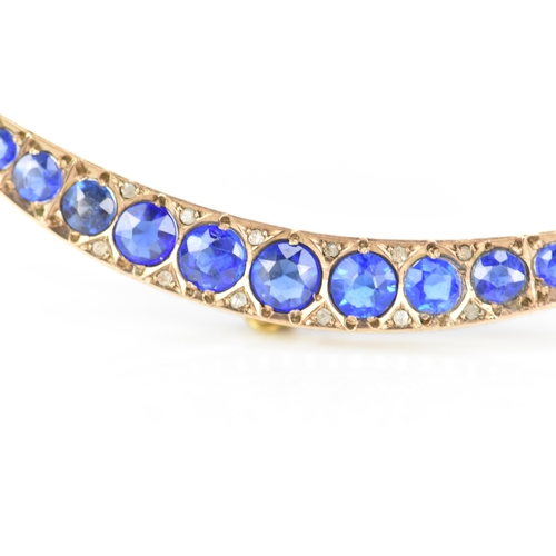 146 - An Edwardian 9ct gold crescent brooch, inset with fifteen blue coloured graduating stones and twelve... 