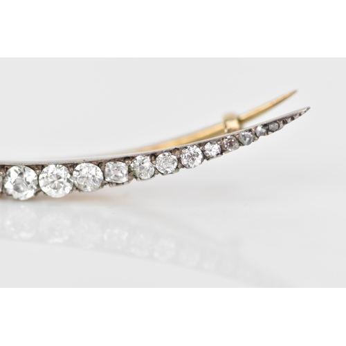 156 - A Victorian yellow and white metal crescent brooch, inset with old and rose cut graduating diamonds ... 