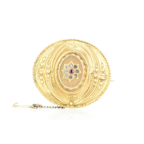 157 - A Victorian 9ct gold Etruscan revival mourning brooch, of oval foliate design, with a central ruby s... 