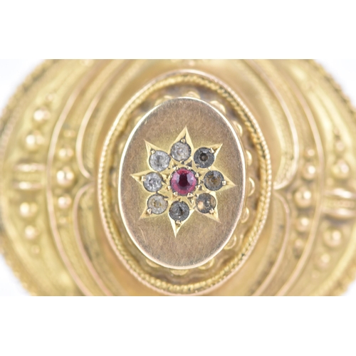 157 - A Victorian 9ct gold Etruscan revival mourning brooch, of oval foliate design, with a central ruby s... 