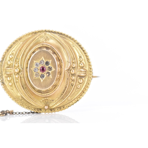 157 - A Victorian 9ct gold Etruscan revival mourning brooch, of oval foliate design, with a central ruby s... 