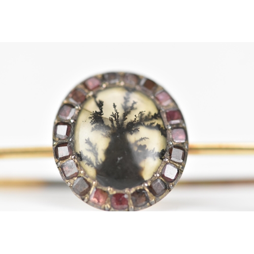 158 - A 19th century yellow metal brooch having an oval agate exhibiting dendritic inclusions, surrounded ... 