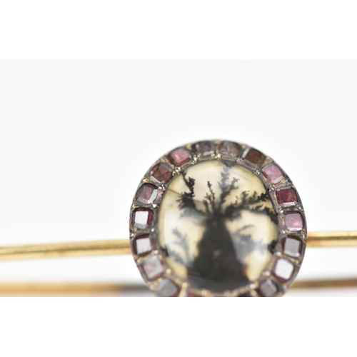 158 - A 19th century yellow metal brooch having an oval agate exhibiting dendritic inclusions, surrounded ... 