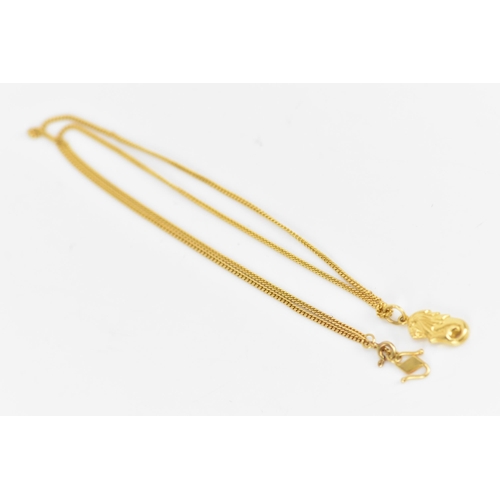 162 - An 18ct yellow gold necklace with two 22ct gold pendants, the curb chain link necklace having a bolt... 