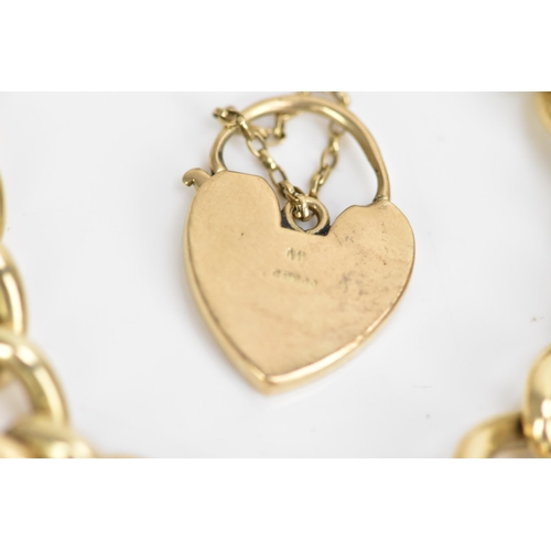 185 - A 9ct rose gold curb link chain bracelet, having a scroll engraved heart shaped padlock clasp and sa... 