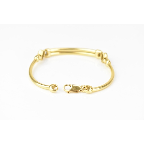 203 - An 18ct yellow gold bracelet, formed as three hoop connected bars, with a lobster clasp, stamped 750... 