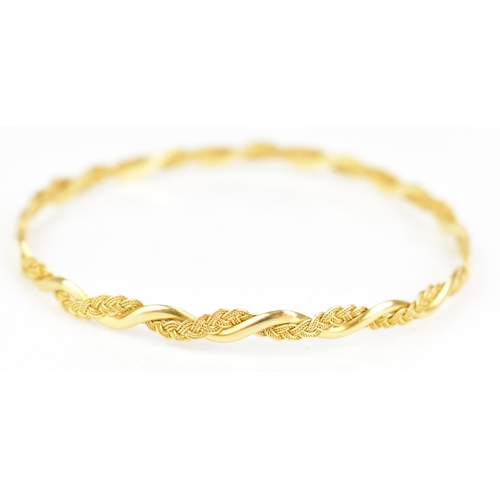 208 - An 18ct yellow gold bangle, cast as an entwined spiga style chain, stamped 18ct, approx 7cm inner di... 