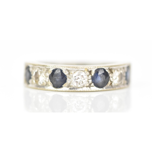 216 - An 18ct white gold diamond and sapphire half eternity ring, inset with four sapphires, each approx 3... 