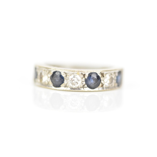 216 - An 18ct white gold diamond and sapphire half eternity ring, inset with four sapphires, each approx 3... 