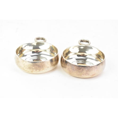 220 - A pair of Elizabeth II silver tastevins, by Carrington & Co, hallmarked London 1970, each having two... 