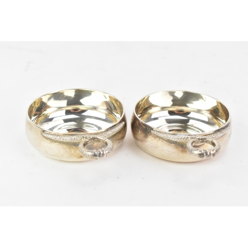 220 - A pair of Elizabeth II silver tastevins, by Carrington & Co, hallmarked London 1970, each having two... 