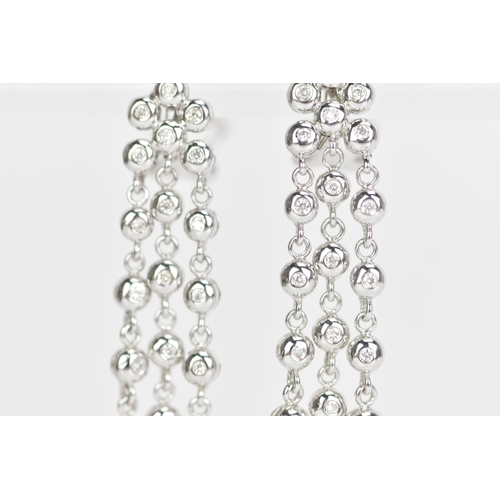 229 - A pair of 18ct white gold and diamond earrings, each composed of three articulated tassel drops and ... 