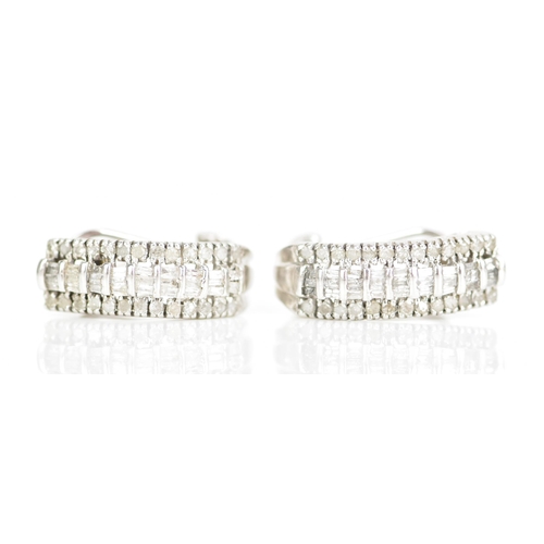 235 - A pair of 10ct white gold diamond earrings, each inset with a row of baguette cut diamonds surrounde... 