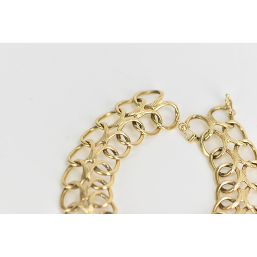 236 - A yellow metal bracelet, of articulated design with two rows of interlocking oval rings, with figure... 