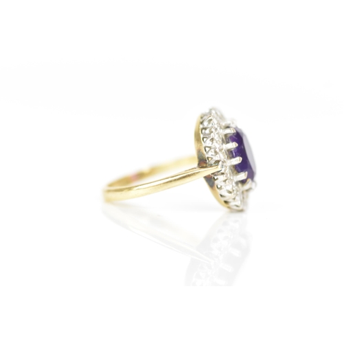 239 - An 18ct yellow gold amethyst and diamond cluster ring, the oval faceted cut amethyst in a caw settin... 