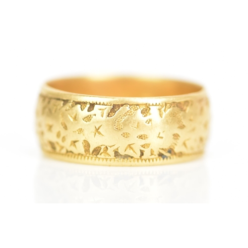 240 - An 18ct yellow gold wedding band, engraved with a floral design, ring size P 1/2, 7.4 grams
If there... 