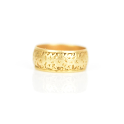 240 - An 18ct yellow gold wedding band, engraved with a floral design, ring size P 1/2, 7.4 grams
If there... 