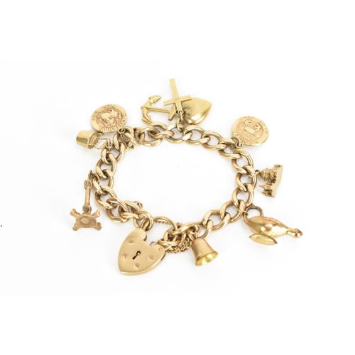 241 - A 9ct gold curb link charm bracelet, with various 9ct gold and yellow metal charms including a candl... 