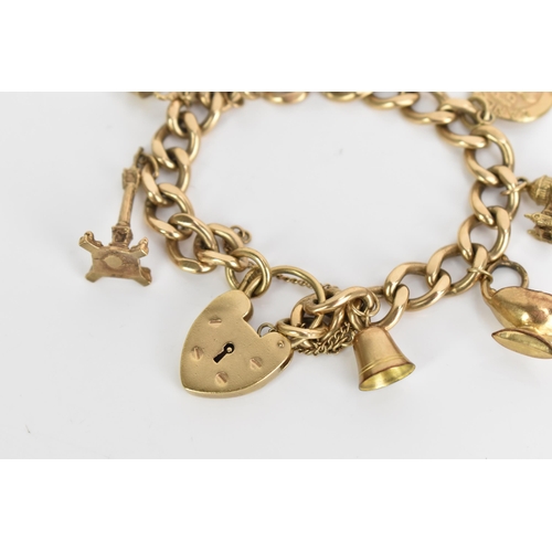 241 - A 9ct gold curb link charm bracelet, with various 9ct gold and yellow metal charms including a candl... 