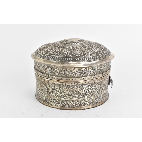 44 - An early 20th century Indian white metal betel box, of circular form, embossed and incised with repe... 