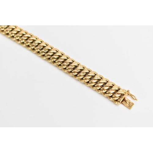 69 - A yellow gold chain link bracelet, tests at 18ct gold, having an open box clasp and with an interloc... 