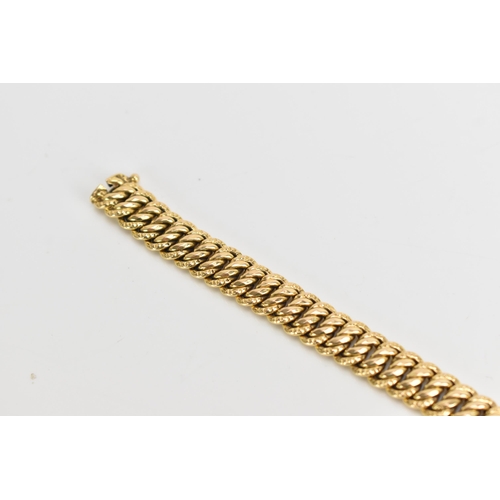 69 - A yellow gold chain link bracelet, tests at 18ct gold, having an open box clasp and with an interloc... 