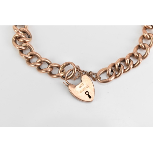 71 - A 9ct rose gold curb link chain bracelet, having a heart shaped padlock clasp and safety chain, stam... 