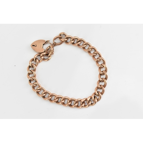 71 - A 9ct rose gold curb link chain bracelet, having a heart shaped padlock clasp and safety chain, stam... 