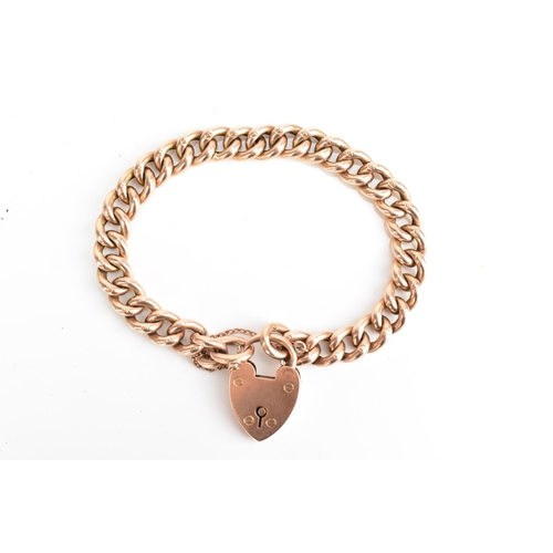 74 - A 9ct rose gold curb link chain bracelet, having a heart shaped padlock clasp and safety chain, appr... 