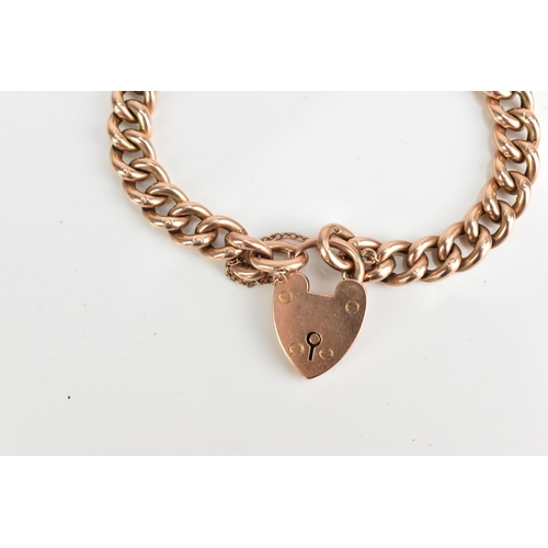 74 - A 9ct rose gold curb link chain bracelet, having a heart shaped padlock clasp and safety chain, appr... 