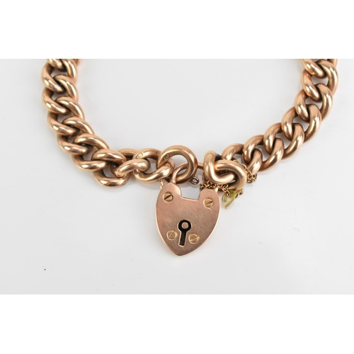 75 - A 9ct rose gold curb link chain bracelet, having a heart shaped padlock clasp and safety chain, appr... 