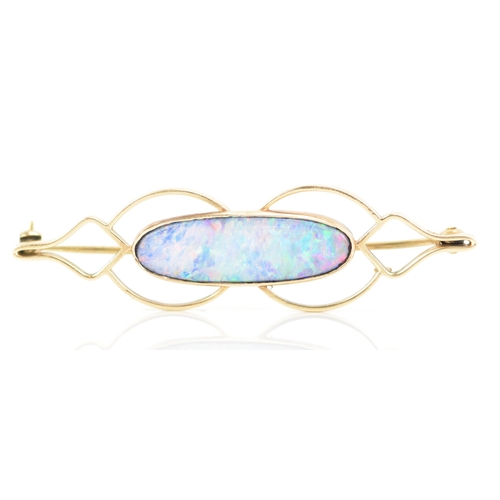 243 - A 9ct yellow gold and opal brooch, the oval opal 25.8mm x 7.7mm set in a pierced frame, stamped 9ct,... 