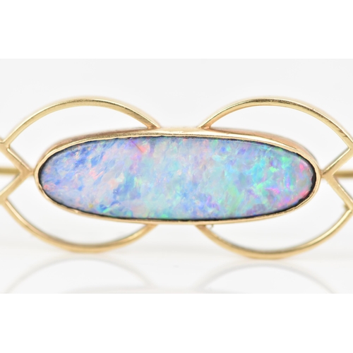 243 - A 9ct yellow gold and opal brooch, the oval opal 25.8mm x 7.7mm set in a pierced frame, stamped 9ct,... 