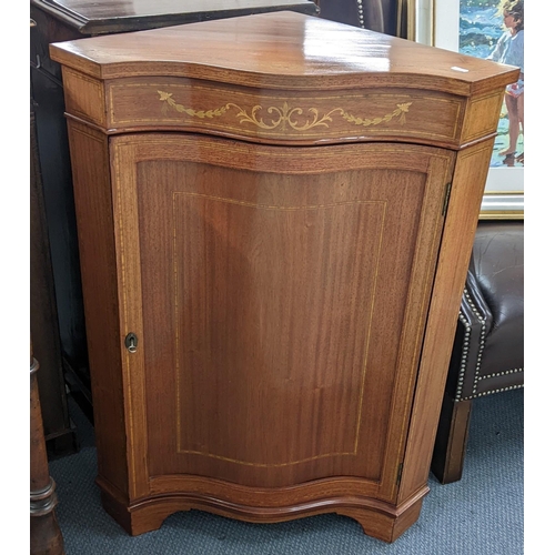 236 - A mid 20th century serpentine fronted, marquetry inlaid corner cabinet, having a single door with bo... 