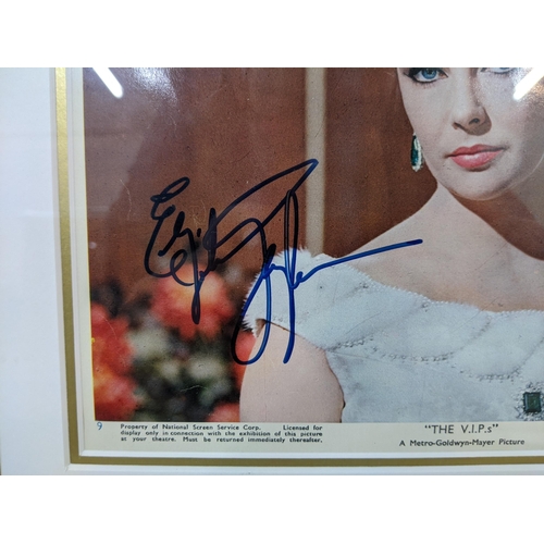 23 - An Elizabeth Taylor signed picture along with four of unsigned pictures mounted together in a frame.... 